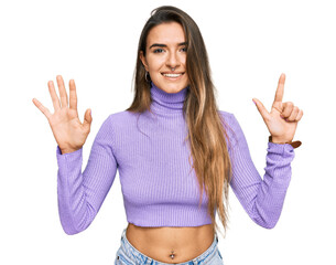 Young hispanic woman wearing casual clothes showing and pointing up with fingers number seven while smiling confident and happy.