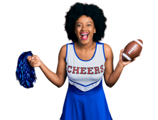 Young african american woman wearing cheerleader uniform holding pompom and football ball smiling and laughing hard out loud because funny crazy joke.