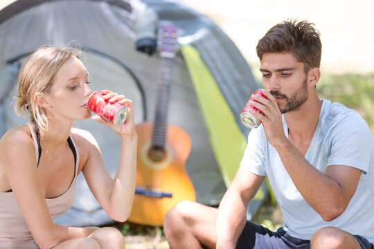 picture of couple outside tent drinking soda