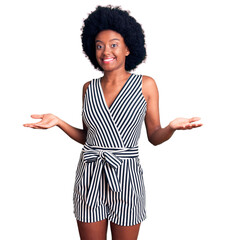 Young african american woman wearing casual clothes clueless and confused expression with arms and...