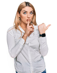 Young caucasian woman wearing casual clothes asking to be quiet with finger on lips pointing with...
