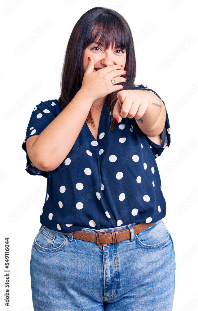 Sticker Young plus size woman wearing casual clothes laughing at you, pointing finger to the camera with hand over mouth, shame expression