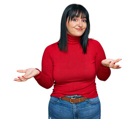 Young hispanic woman wearing casual clothes clueless and confused expression with arms and hands...