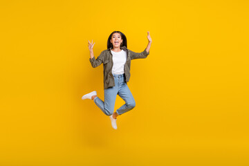 Fototapeta na wymiar Full body length photo of young smiling chinese woman celebrate hands up jumping air after working days finished isolated on yellow color background