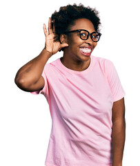 African american woman with afro hair wearing casual clothes and glasses smiling with hand over ear...