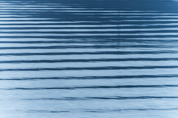 Surface ripples background of parallel lines of shade and light.