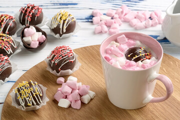 Cocoa bombs are black chocolate shells filled with cocoa powder and marshmallows that melt when hot milk is added, open in a mug and create a trendy delicious drink. 