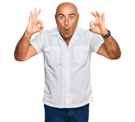 Mature middle east man with mustache wearing casual white shirt looking surprised and shocked doing ok approval symbol with fingers. crazy expression