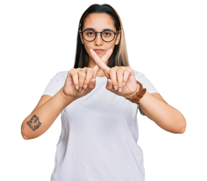 Young hispanic woman wearing casual white t shirt rejection expression crossing fingers doing negative sign