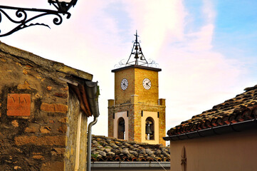 prime luci del tramonto sul campanile con orologio della chiesa di un piccolo borgo 
