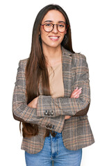 Young hispanic girl wearing business clothes and glasses happy face smiling with crossed arms...