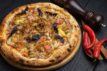 tasty pizza with cheese and vegetables on a wooden dark table
