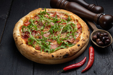 tasty pizza with cheese and vegetables on a wooden dark table
