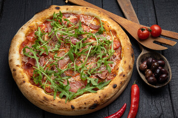 tasty pizza with cheese and vegetables on a wooden dark table
