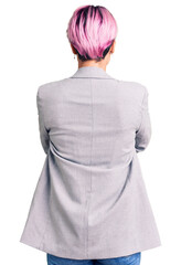 Young beautiful woman with pink hair wearing casual clothes standing backwards looking away with crossed arms