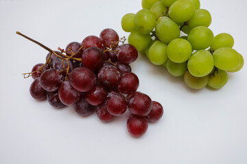 fresh greens and red grapes on a white background
