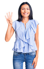 Young beautiful latin girl wearing casual clothes showing and pointing up with fingers number four while smiling confident and happy.