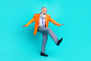 Fototapeta na wymiar Full length photo of pretty funky retired man dressed bright orange jacket walking having fun discotheque isolated turquoise color background