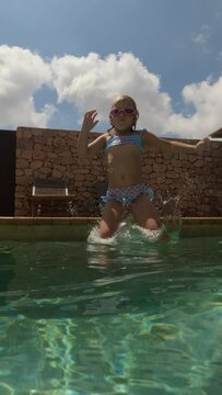 Slow motion vertical video - girl diving into the outdoor pool