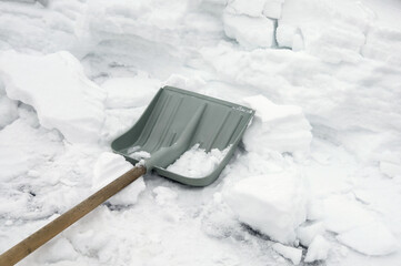 Shovel for removing snow is on surface of road, snow winter, a lot of work to clean snow