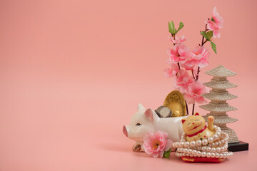 Maneki Neko plastic cat symbol of good luck and wealth on pink background.