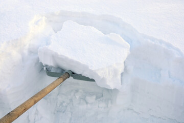 Textured surface, shovel is filled with a lot of snow, clean road, snowy winter