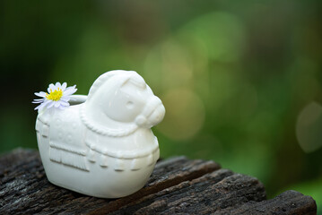 Old white ceramic horse decorated with daisies flower on nature background.