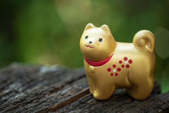 Old  golden dog bell ornament figurine good luck rich on nature background.