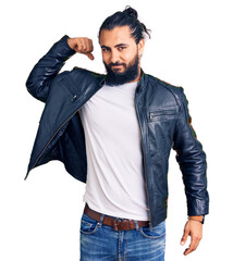 Young arab man wearing casual leather jacket strong person showing arm muscle, confident and proud of power