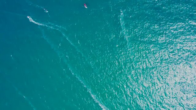 Drone view with a rotation of windsurfers with kites surfing on the sea with a blue sky and sea. Water sport with windsurfing and kitesurfing race