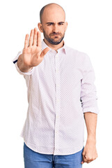 Young handsome man wearing elegant shirt doing stop sing with palm of the hand. warning expression with negative and serious gesture on the face.