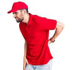 Young handsome man with beard wearing delivery uniform suffering of backache, touching back with hand, muscular pain