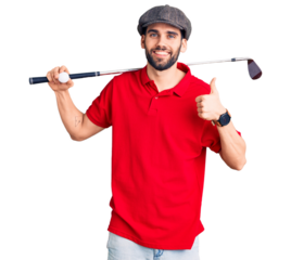 Young handsome man with beard playing golf holding club and ball smiling happy and positive, thumb up doing excellent and approval sign
