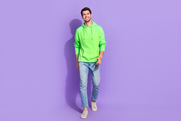 Full length size photo of young attractive stylish model man wear nice green pullover cheap jeans trendy sneakers isolated on purple color background
