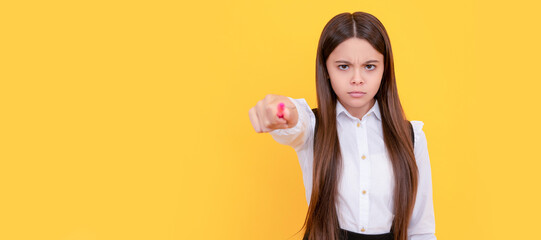Serious frown school girl point pen putting out hand yellow background, back to school. Banner of school girl student. Schoolgirl pupil portrait with copy space.