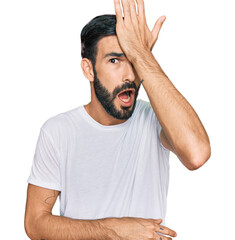 Young hispanic man wearing casual white t shirt surprised with hand on head for mistake, remember error. forgot, bad memory concept.