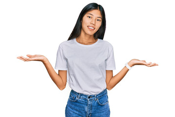 Beautiful young asian woman wearing casual white t shirt smiling showing both hands open palms, presenting and advertising comparison and balance