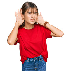 Obraz na płótnie Canvas Teenager caucasian girl wearing casual red t shirt trying to hear both hands on ear gesture, curious for gossip. hearing problem, deaf