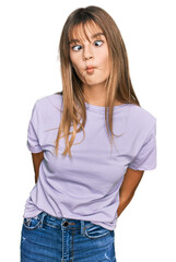 Fototapeta premium Teenager caucasian girl wearing casual clothes making fish face with lips, crazy and comical gesture. funny expression.