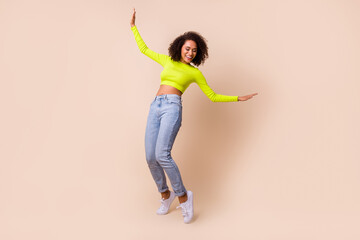 Full length photo of young happy smiling woman drunk dancing showing elastic isolated on beige color background