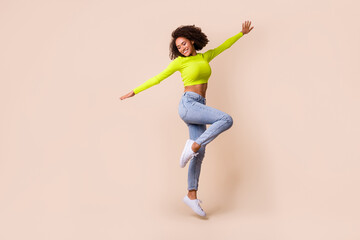 Full length photo of young attractive girl happy go travel fly wings dancing isolated on beige color background