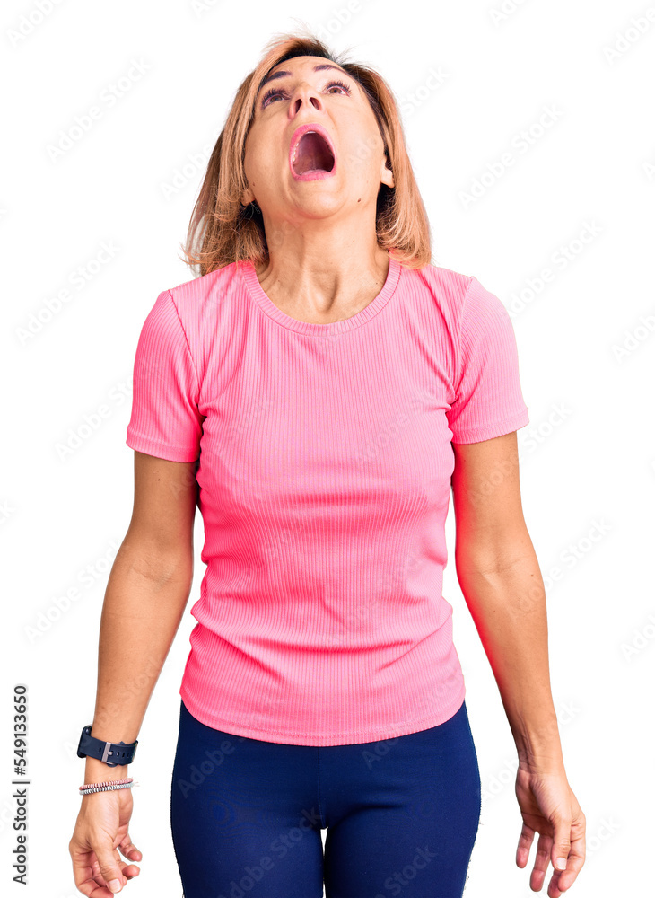 Sticker young blonde woman wearing sportswear angry and mad screaming frustrated and furious, shouting with 