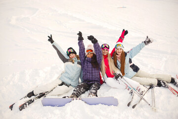 Group of girls spend time together skiing in mountains