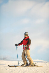 Fototapeta na wymiar Guy deftly skis in sunny weather and has fun
