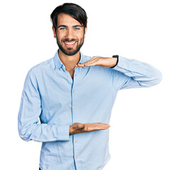 Hispanic man with blue eyes wearing business shirt gesturing with hands showing big and large size...