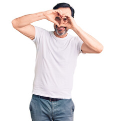Fototapeta premium Middle age handsome man wearing casual t-shirt doing heart shape with hand and fingers smiling looking through sign
