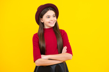 Happy teenager portrait. Teenage girl kid with crossed arms, looking at camera, isolated on yellow studio background. Smiling girl.