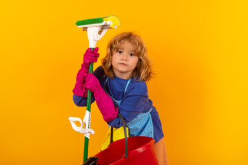 Child cleans at home concept. Kid cleaning with mop to help with housework. Little cute boy...