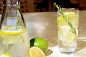 Tasty refreshing lemonade and ingredients on light table. Summer drink