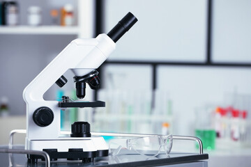 Modern medical microscope on metal table in laboratory, space for text